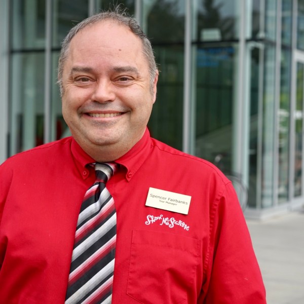 a man wearing a suit and tie smiling at the camera