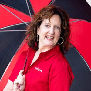 a woman standing in the rain holding an umbrella
